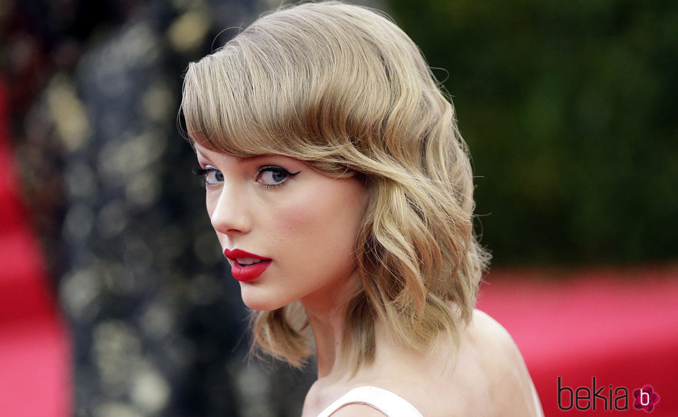 Taylor Swift con flequillo desfilado y pelo ondulado
