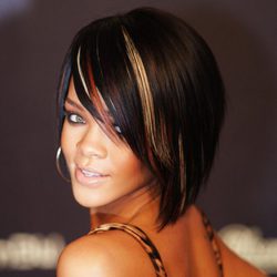 Peinado de Rihanna con media melena tipo bob y flequillo ladeado en color castaño con mechas rubias