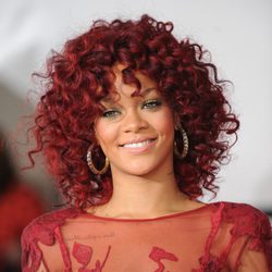 Peinado de Rihanna con melena larga y rizo afro en color rojo
