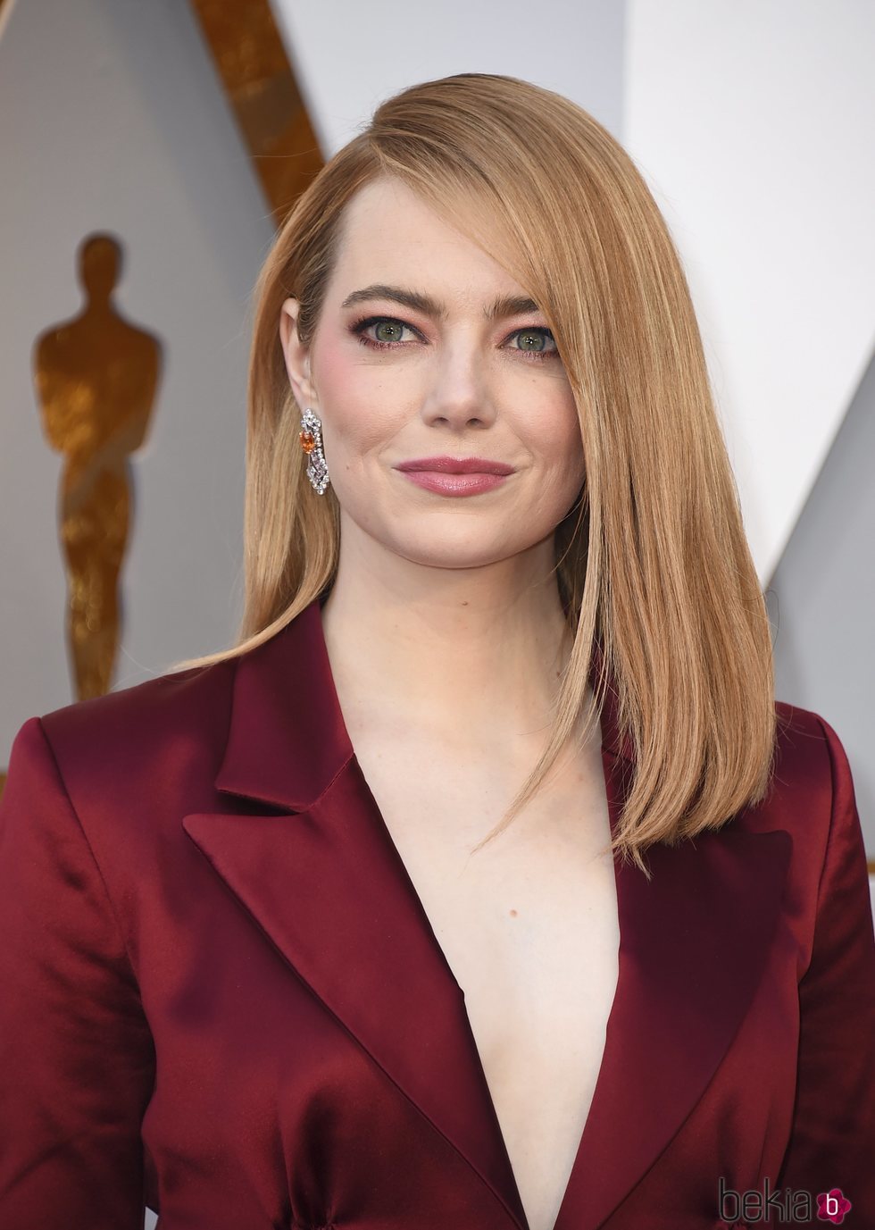 Emma Stone con el pelo liso y la raya al lado en los Oscar 2018